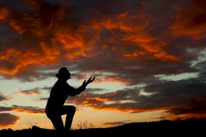 A man worshiping God at a spectacular sunset after a storm